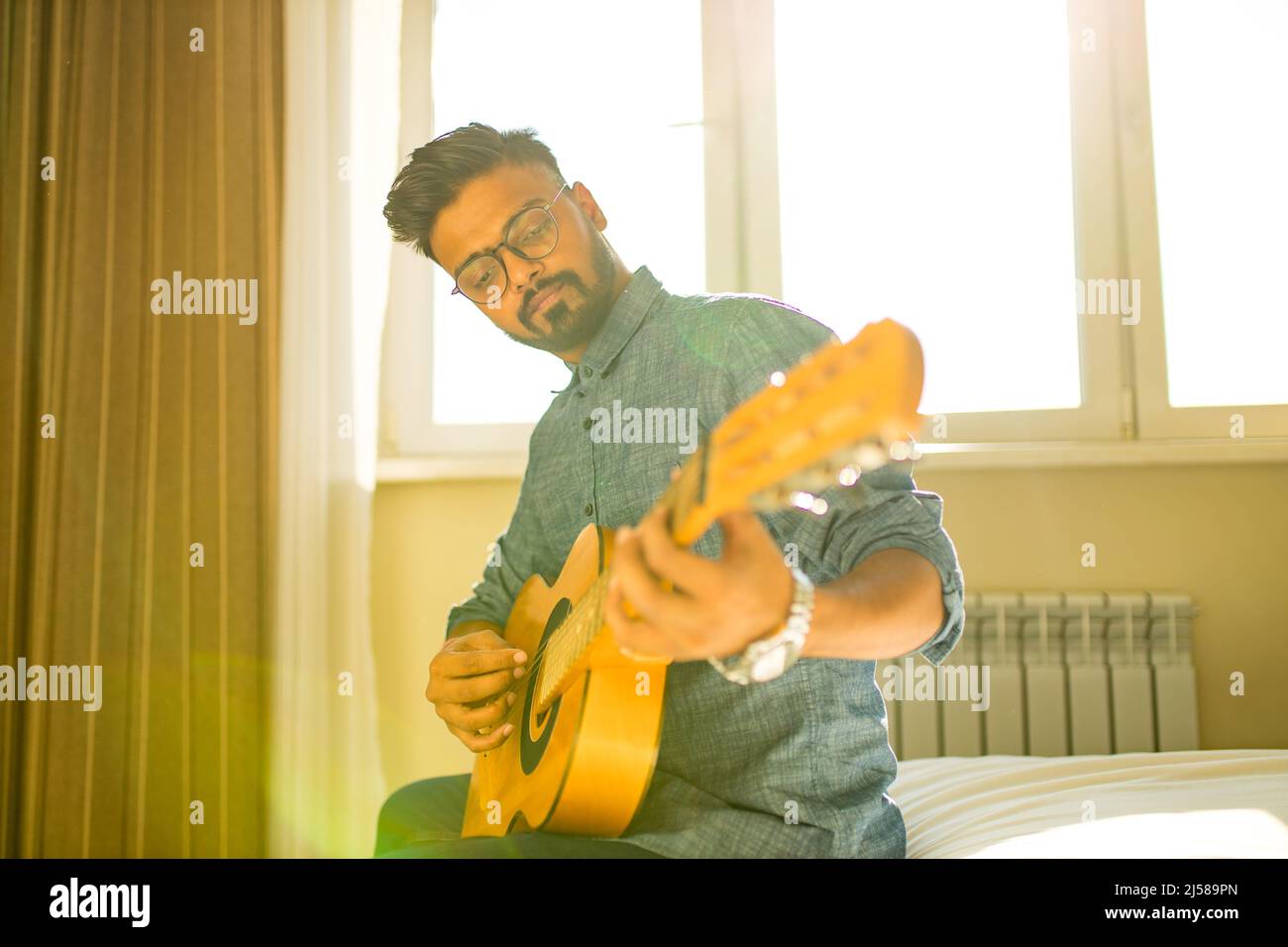 Geben Gitarre online lektion.indischer Mann spielt die Gitarre Stockfoto