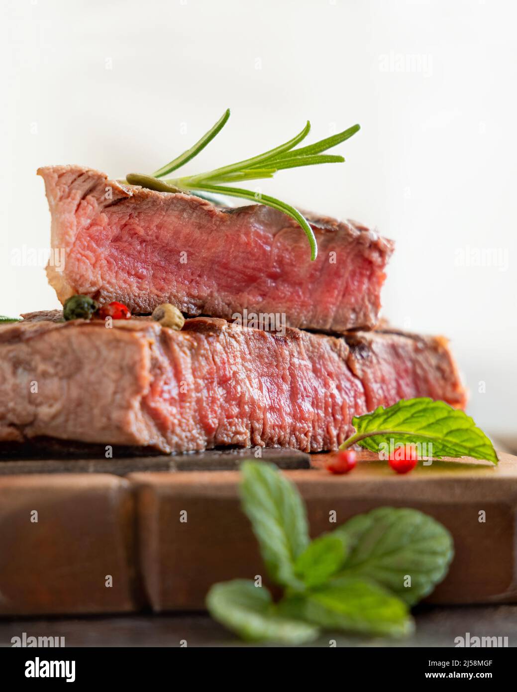 Gegrillte Rinderfilet-Steaks auf dunklem Tisch aus nächster Nähe. Portioniertes Filet Mignon mit Gewürzen und Kräutern. Konzept der Sommerkost, Fleischesser. Stockfoto