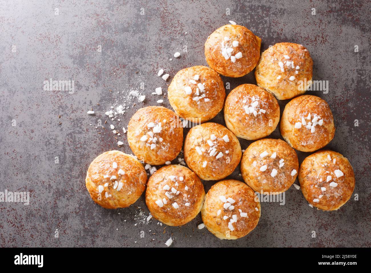 Hausgemachtes süßes heißes Badegebun mit Kreuzkümmel und Zucker aus nächster Nähe auf dem Tisch. Horizontale Draufsicht von oben Stockfoto