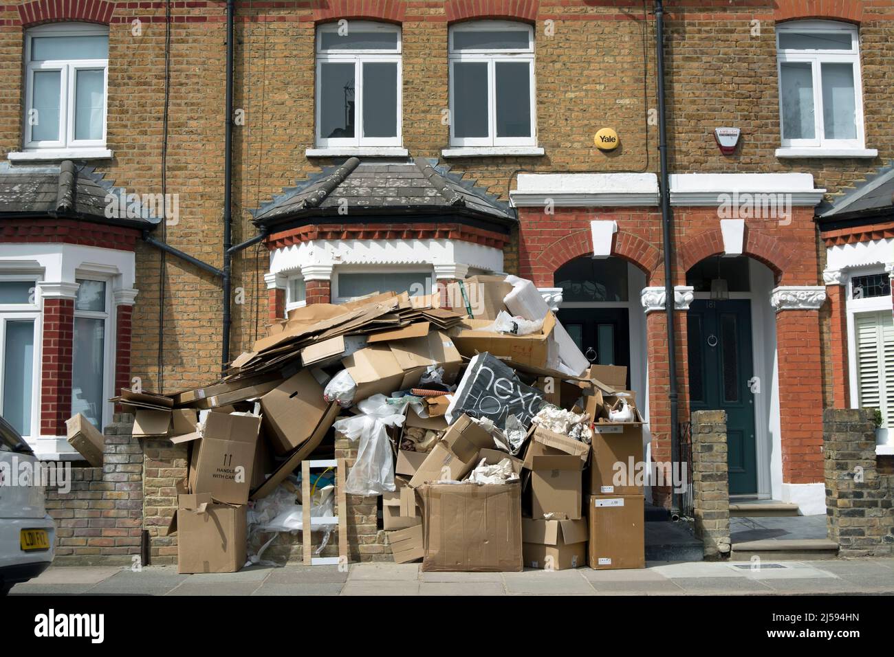 Vor einem viktorianischen Haus auf der mittleren Terrasse in twickemham, middlesex, england, stapelten sich Kartons mit ausrangierten Verpackungen und anderem Müll Stockfoto
