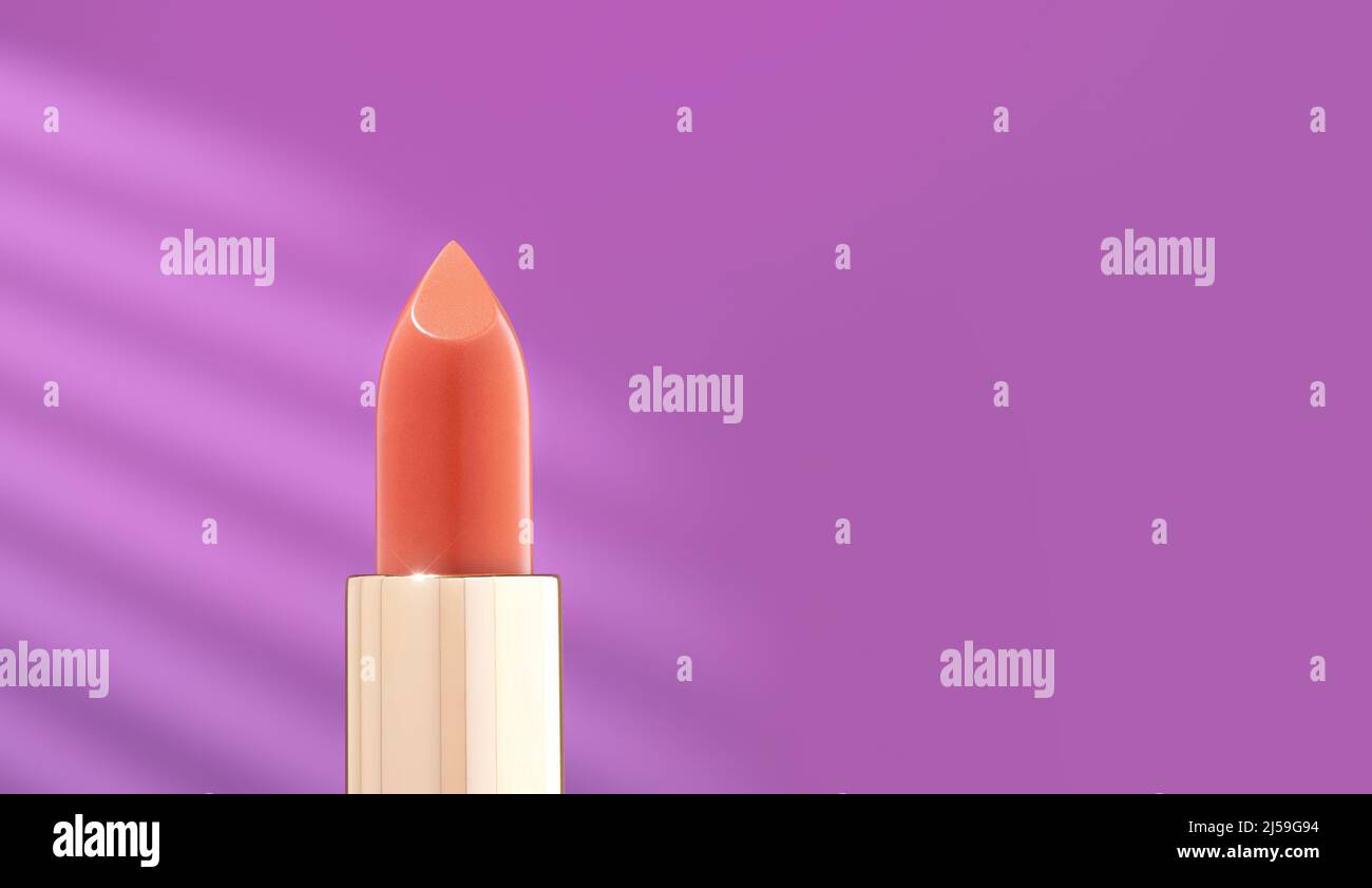 Ein leuchtend roter Lippenstift in einem goldenen Gehäuse auf violettem Hintergrund. Dekorative Kosmetik auf hellviolettem Hintergrund mit Sonnenlicht. Gesichtskosmetik Stockfoto