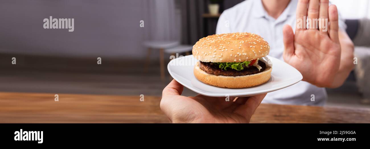 Close-up In eines Mannes Hand ablehnen, Burger von Person Stockfoto