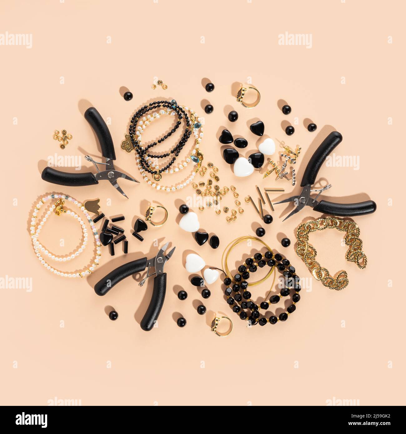 Werkzeuge und Zubehör für DIY-Schmuck am Arbeitsplatz. Flach lag auf beigem Hintergrund. Kreative flache Laie, quadratische Draufsicht. DIY Handwerk Hobby, hausgemacht Stockfoto