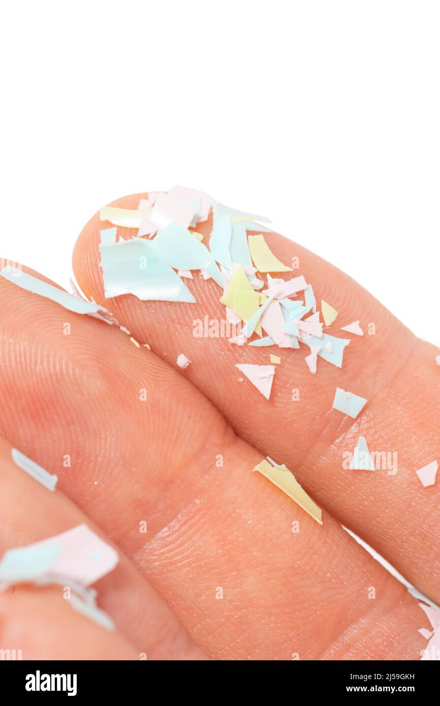 Ein Nahaufnahme-Foto von Mikroplastik lag auf menschlicher Hand. Konzept der Wasserverschmutzung und der globalen Erwärmung. Die Idee von Umweltschäden. Weißer Hintergrund Stockfoto