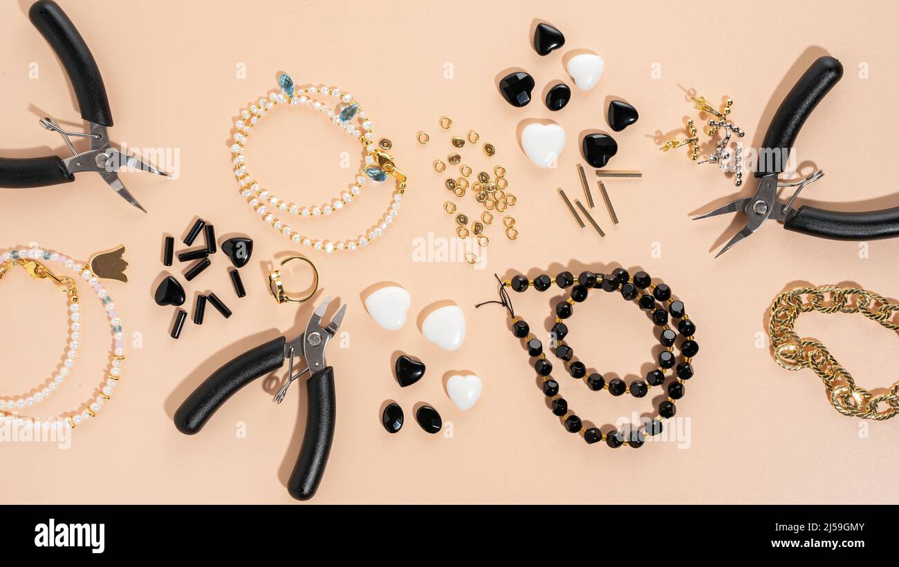 Werkzeuge und Zubehör für DIY-Schmuck am Arbeitsplatz. Flach lag auf beigem Hintergrund. Kreative flache Lay, Banner, Draufsicht. DIY Handwerk Hobby, hausgemacht Stockfoto