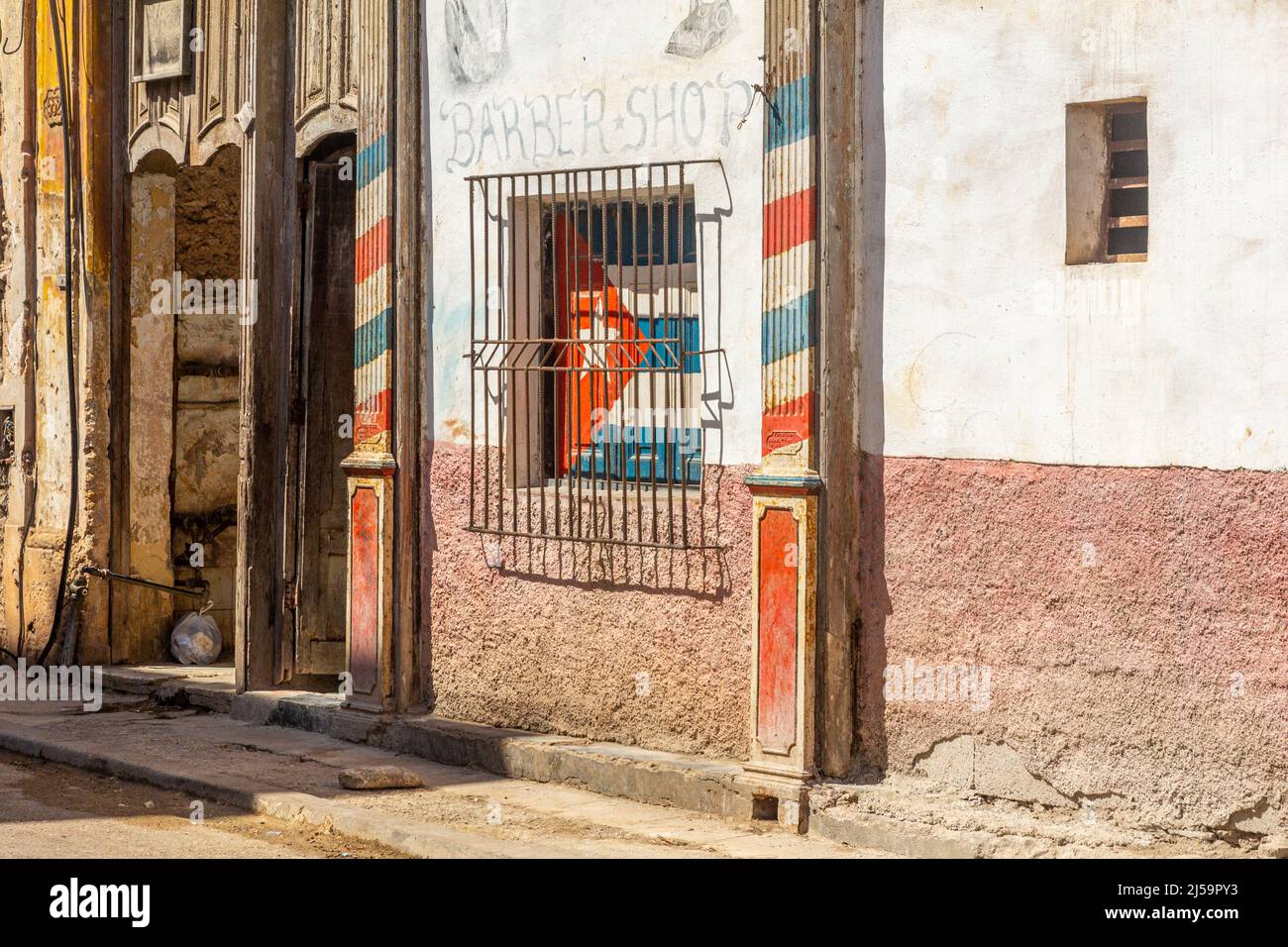 Heruntergekommenen Türen von Wohnhäusern in einem Innenbezirk in der kubanischen Hauptstadt. Die kubanische Flagge ist in einem Fenster zu sehen, das von einem metallischen gri geschützt ist Stockfoto