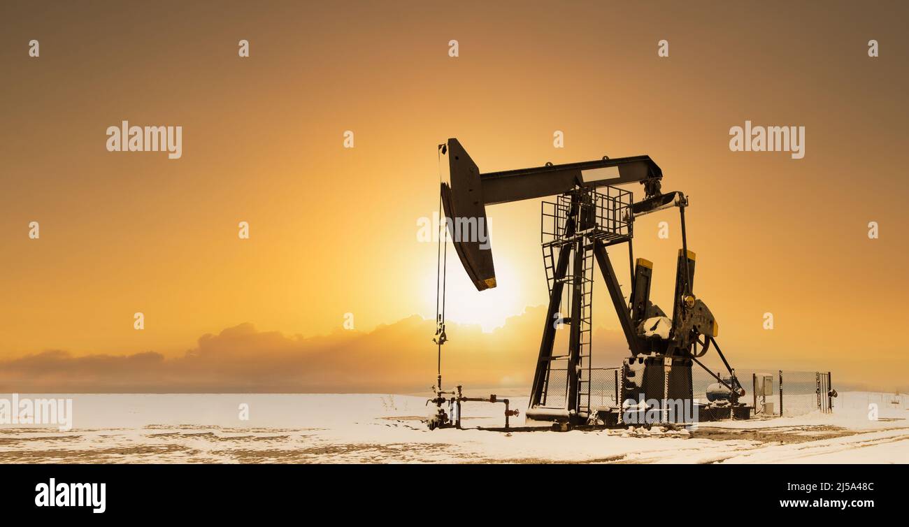 Ölfeld im Sonnenaufgang. Ölpumpen laufen. Industrielle Energiemaschine Stockfoto