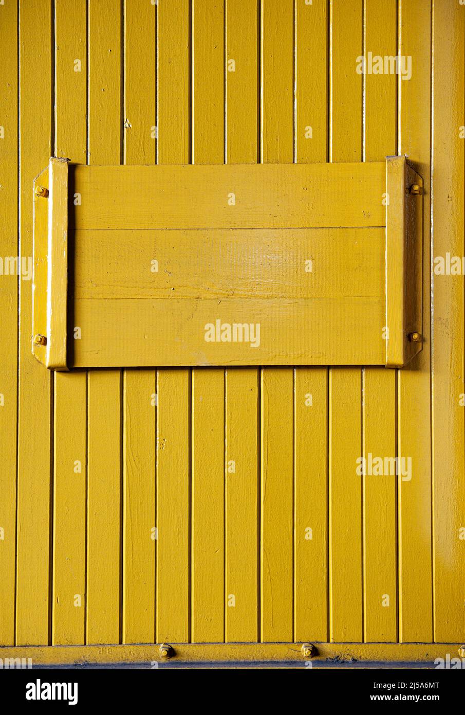 Gelbe ockerfarbene Vertäfelung, horizontale Holzplatte Stockfoto