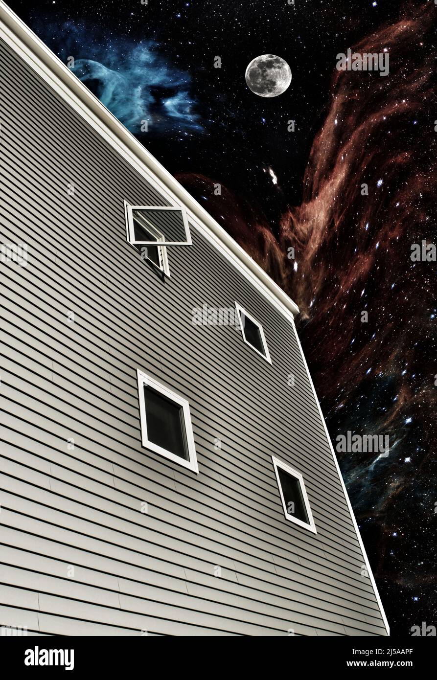 SKYBOX: Die galaktische Weite des Universums existiert am Nachthimmel vor dem Fenster eines Mehrfamilienhauses. Stockfoto