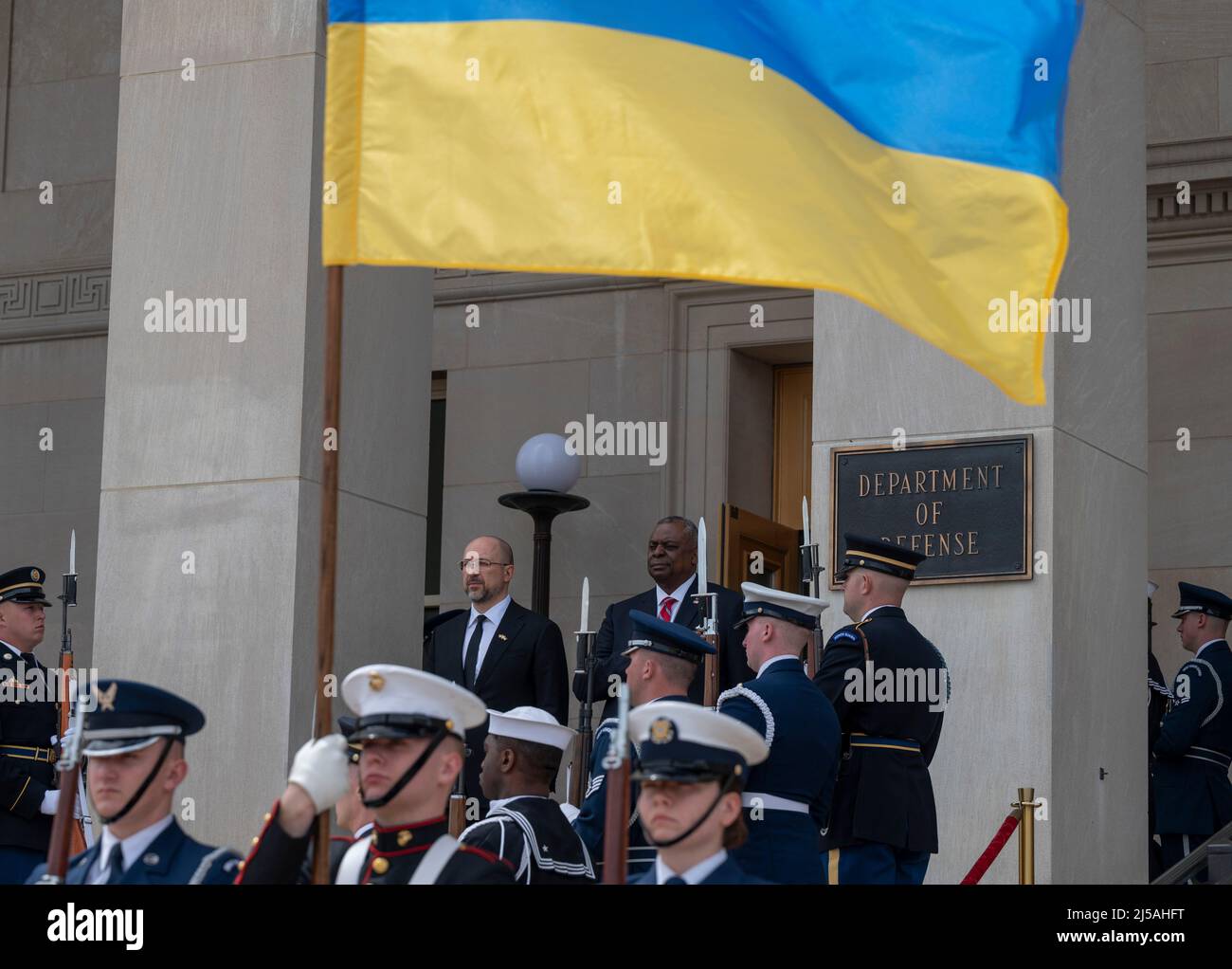 Arlington, Vereinigte Staaten Von Amerika. 14. März 2022. Arlington, Vereinigte Staaten von Amerika. 14. März 2022. Der US-Verteidigungsminister Lloyd J. Austin III, rechts, steht mit der ukrainischen Flagge über dem Himmel für das Spiel der Nationalhymnen mit dem ukrainischen Premierminister Denys Shmyhal während der Ankunftszeremonie im Pentagon am 21. April 2022 in Arlington, Virginia. Kredit: SSGT. Brittany Chase/DOD/Alamy Live News Stockfoto