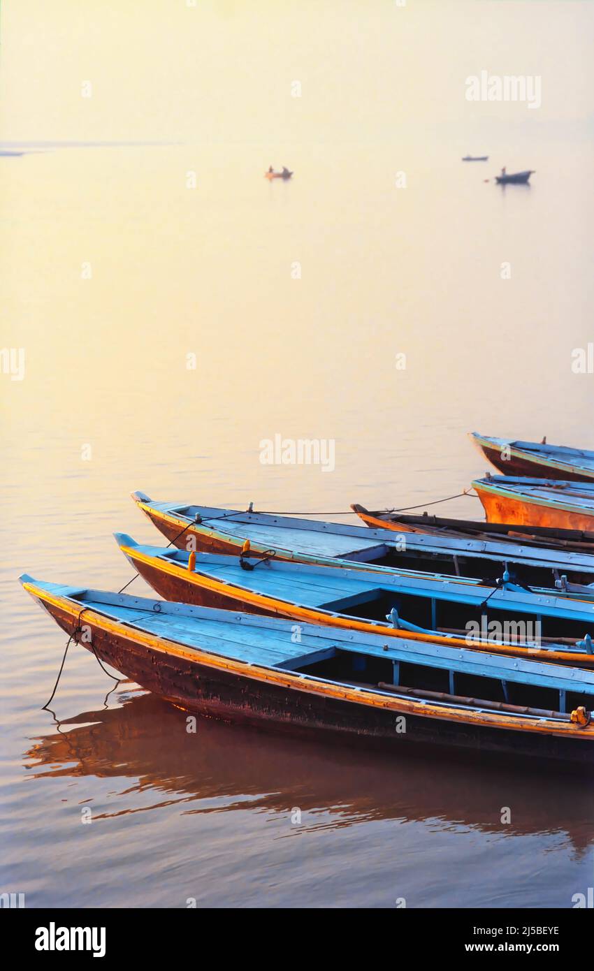 Hölzerne Ruderboote ankerten am Ufer des Flusses Ganges in der Morgendämmerung, Varanasi, Uttar Pradesh, Indien Stockfoto