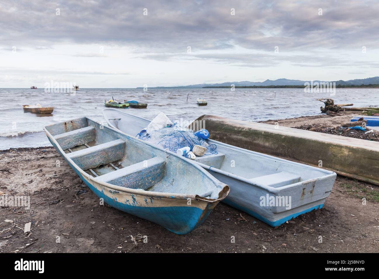 Kleine Boote lagen an der Küste der Samana Bay an einem bewölkten Tag, Dominikanische Republik Stockfoto