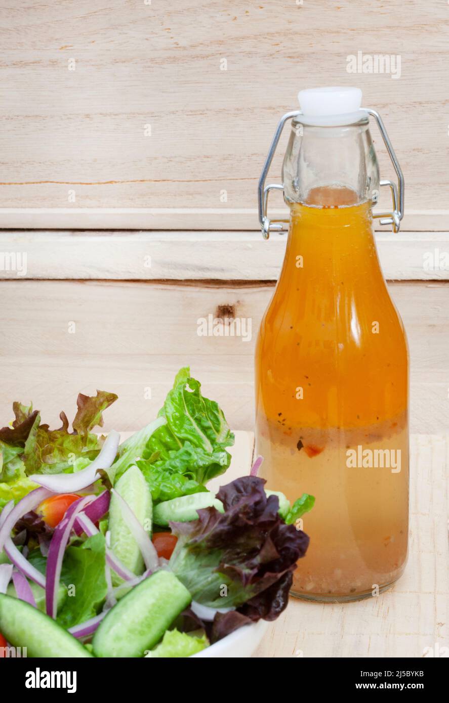 Hausgemachtes Salatdressing mit Beilagen-Salat auf rustikalem Tisch mit Kopierfläche Stockfoto
