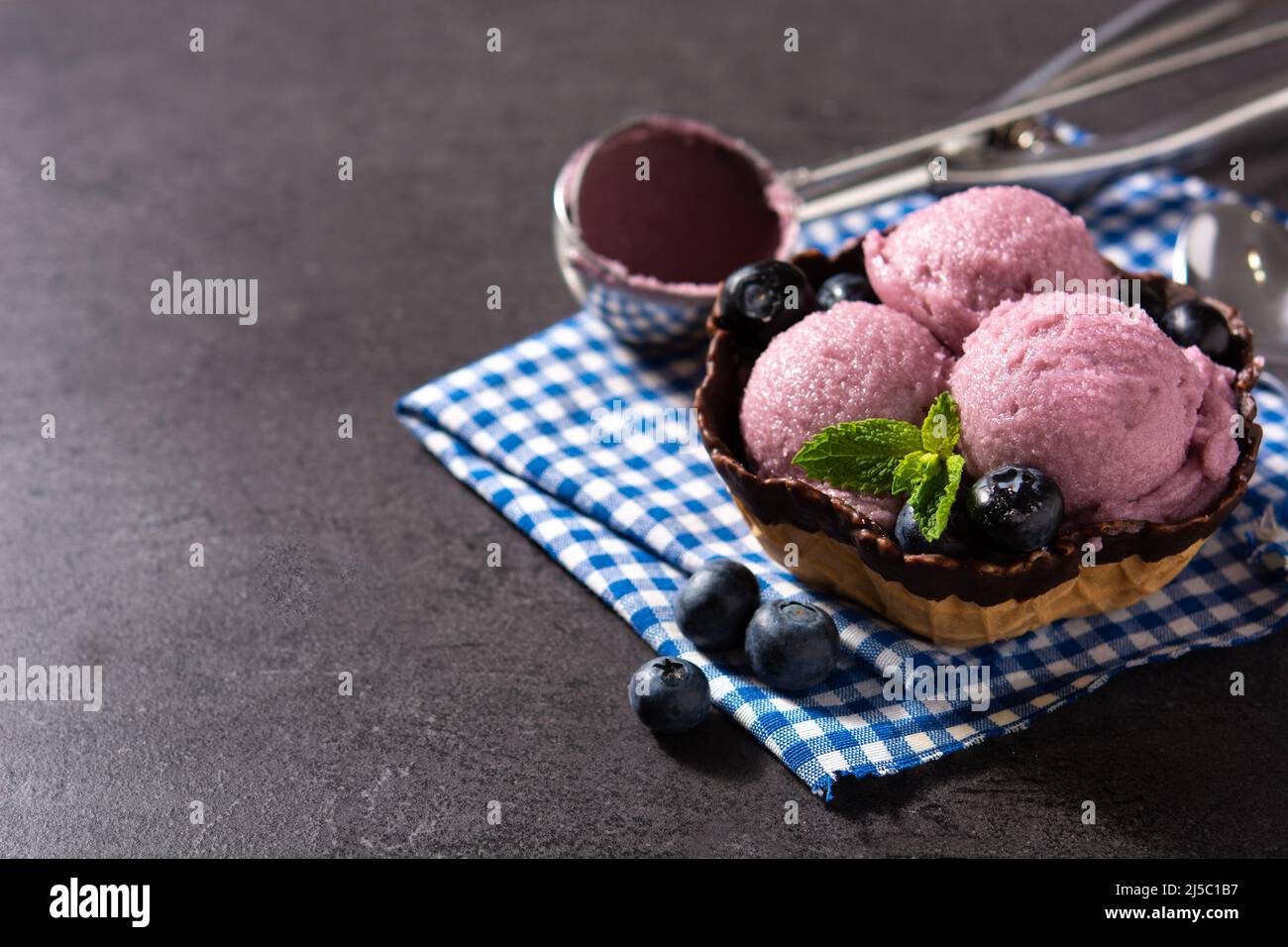 Heidelbeer-Eislöffel auf schwarzem Schiefer-Hintergrund Stockfoto