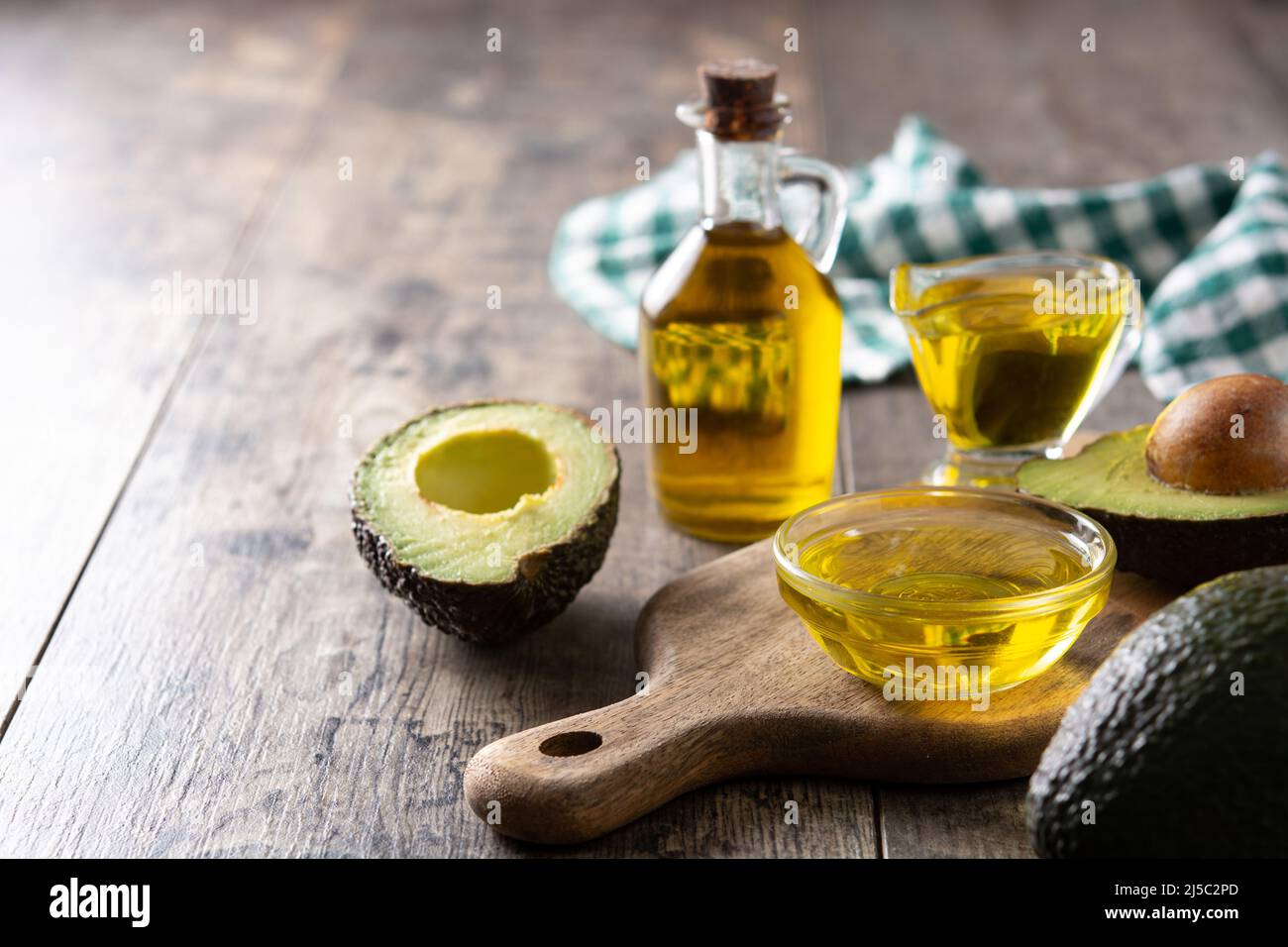 Öl und reife frische Avocado auf rustikalem Holztisch Stockfoto
