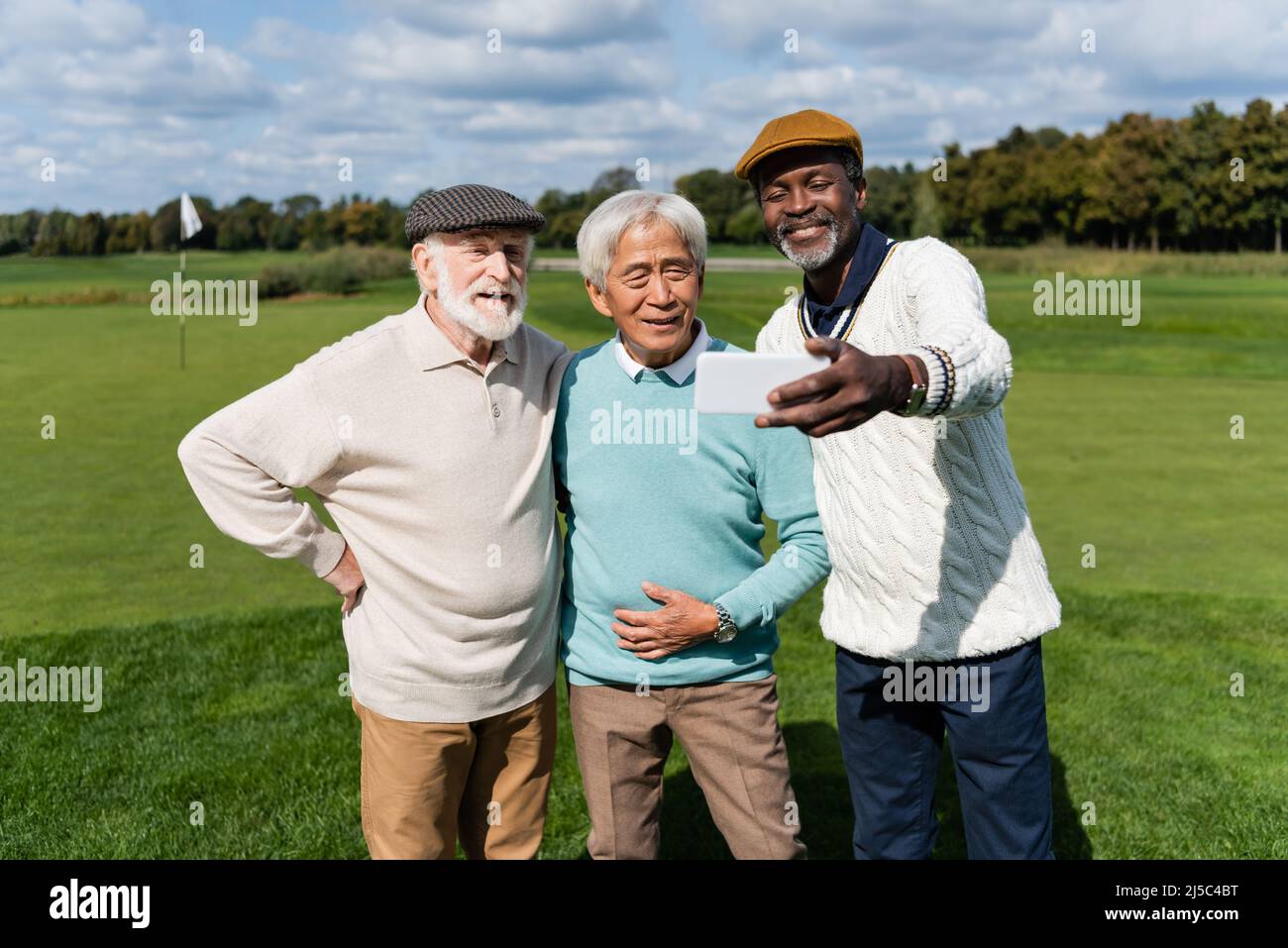 Glücklicher afroamerikanischer Mann, der Selfie mit älteren interracial Freunden macht Stockfoto