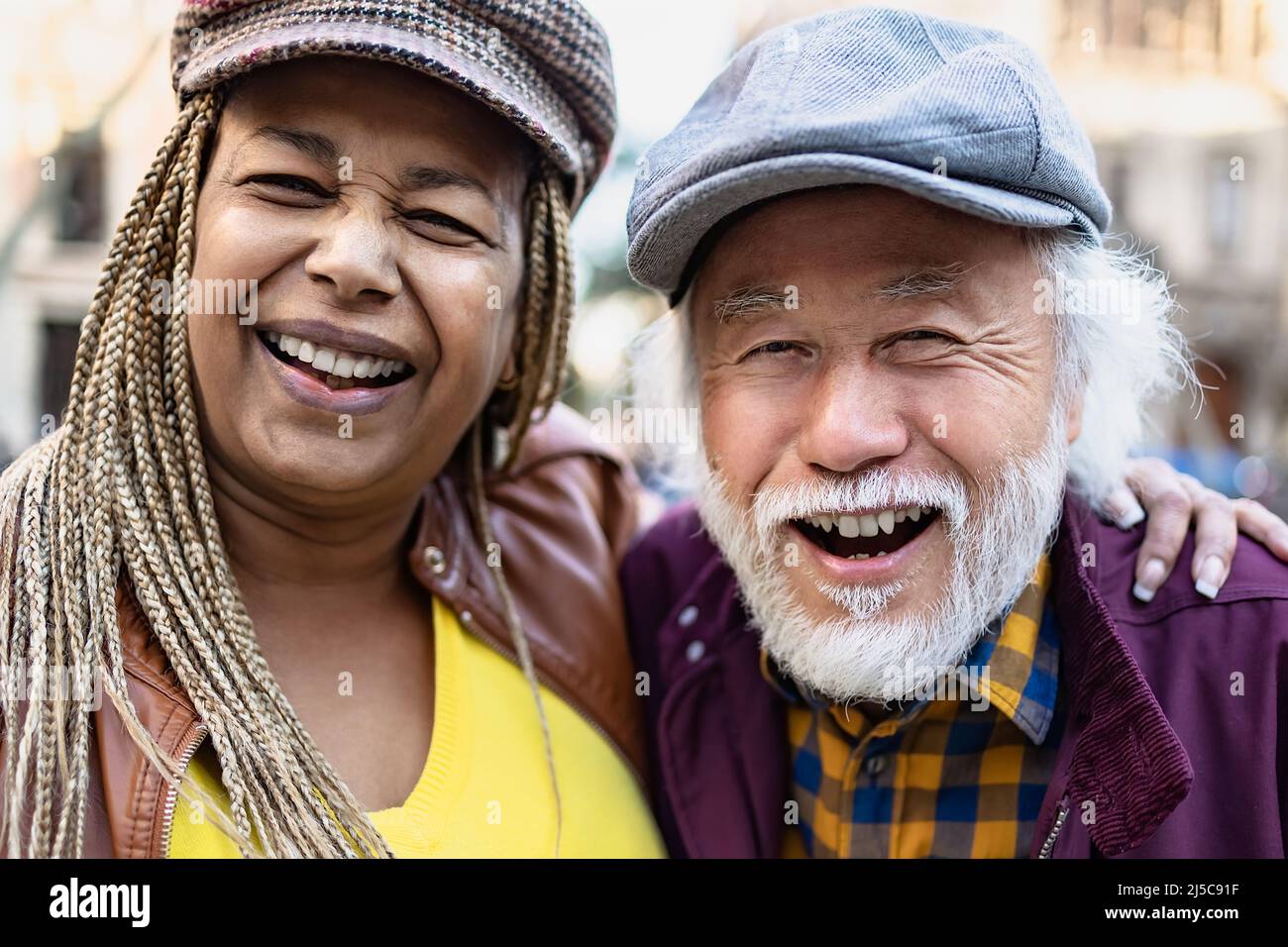 Glückliches multirassisches Seniorenpaar mit Spaß in der Stadt - ältere Menschen und Liebe Beziehung Konzept Stockfoto