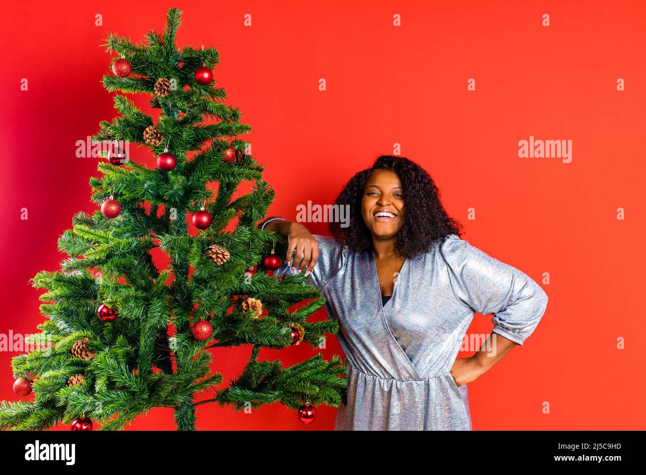 afro spanierin feiert weihnachten in silbernem Kleid Stockfoto