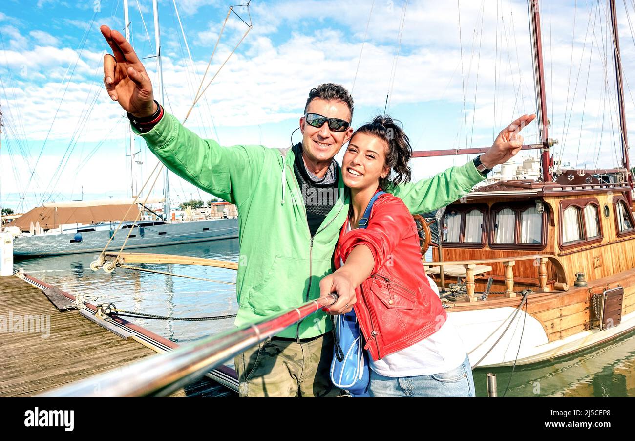 Ein junges Paar Liebhaber, das Selfie an den Segelbooten macht, auf einer Weltreise - Liebeskonzept mit einem glücklichen Freund und einer Freundin auf einer Hochzeitsreise Stockfoto