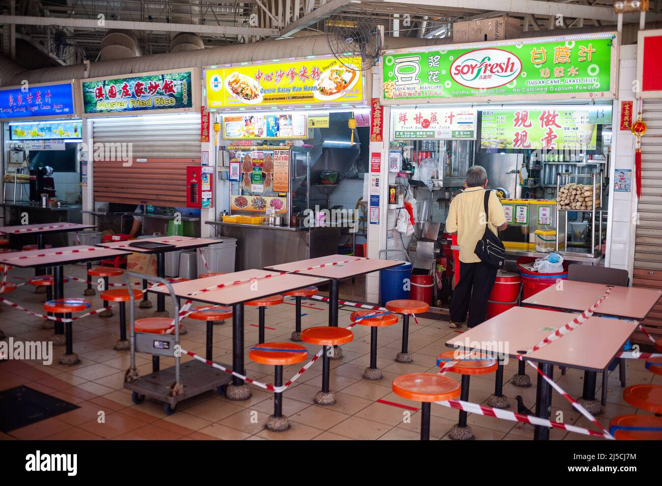 04/22/2020, Singapur, Republik Singapur, Asien - der Essbereich eines Hawker Centers im Bezirk Ang Mo Kio wurde mit rot-weißem Schutzband abgesperrt, um die Ausbreitung des pandemischen Coronavirus weiter zu begrenzen. Seit Inkrafttreten des Leistungsschalters wurden zusätzliche Vorsichtsmaßnahmen ergriffen, wie die Schließung aller nicht unbedingt notwendigen Geschäfte, Einzelhändler und einiger kleiner Restaurants. Einige Restaurants verkaufen weiterhin Lebensmittel, die nur weggenommen werden können. Der Verzehr vor Ort ist verboten. [Automatisierte Übersetzung] Stockfoto