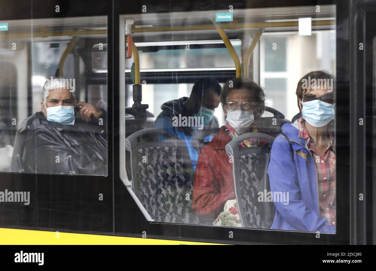 Passagiere mit Gesichtsmasken in einem Bus. In Deutschland ist es nun Pflicht, im öffentlichen Verkehr eine Gesichtsmaske zu tragen. [Automatisierte Übersetzung] Stockfoto