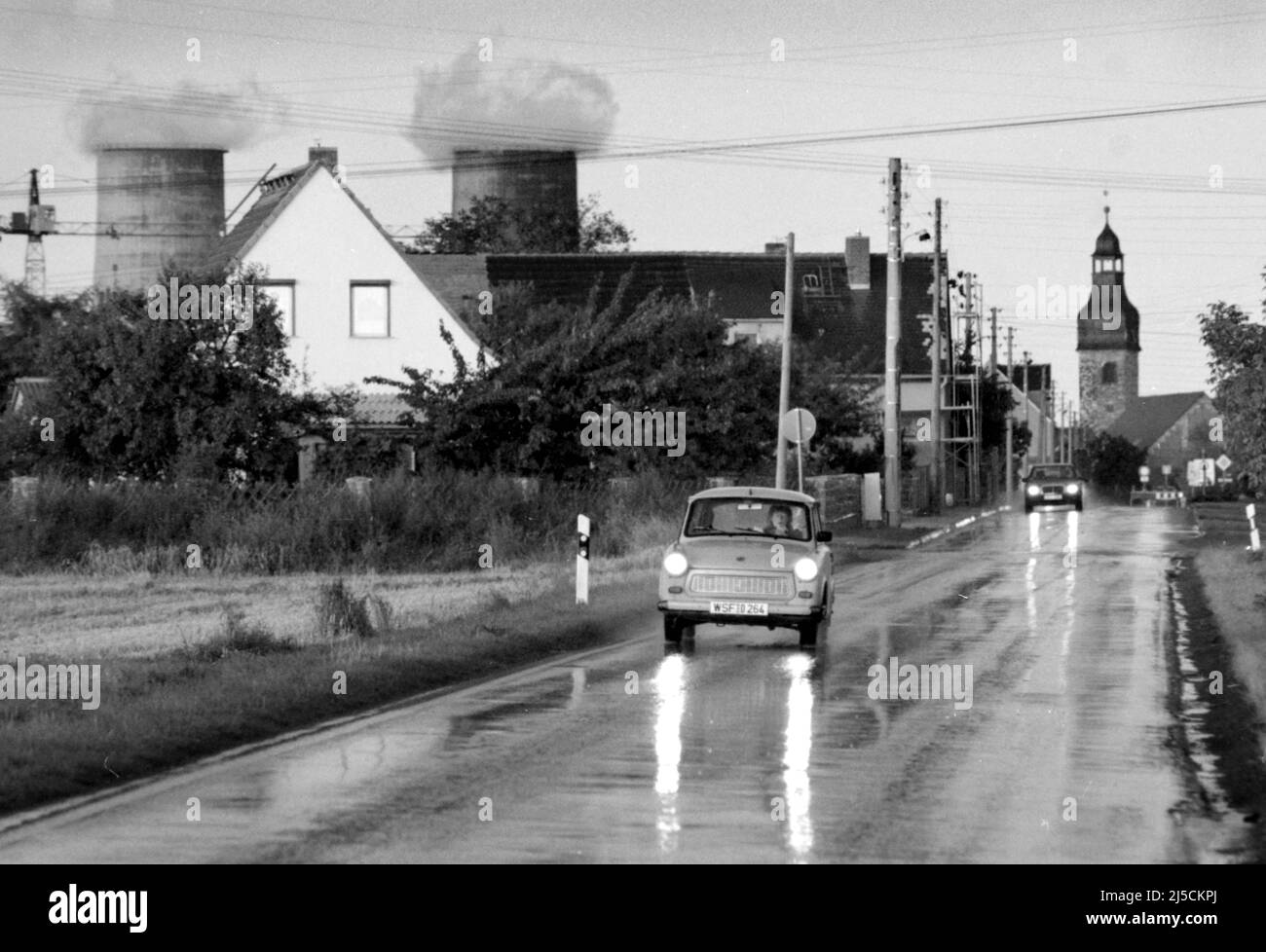 Leuna, DEU, 09.09.1996 - Ein Trabant und ein Mercedes Benz fahren auf einer Straße in Leuna, im Hintergrund ein Kraftwerk. Die Leunawerke in Leuna waren die größte Hydrierungsanlage Deutschlands und in DDR-Zeiten die größte Anlage der chemischen Industrie. Heute befinden sich auf dem Gelände der Leunawerke neue Unternehmen. [Automatisierte Übersetzung] Stockfoto