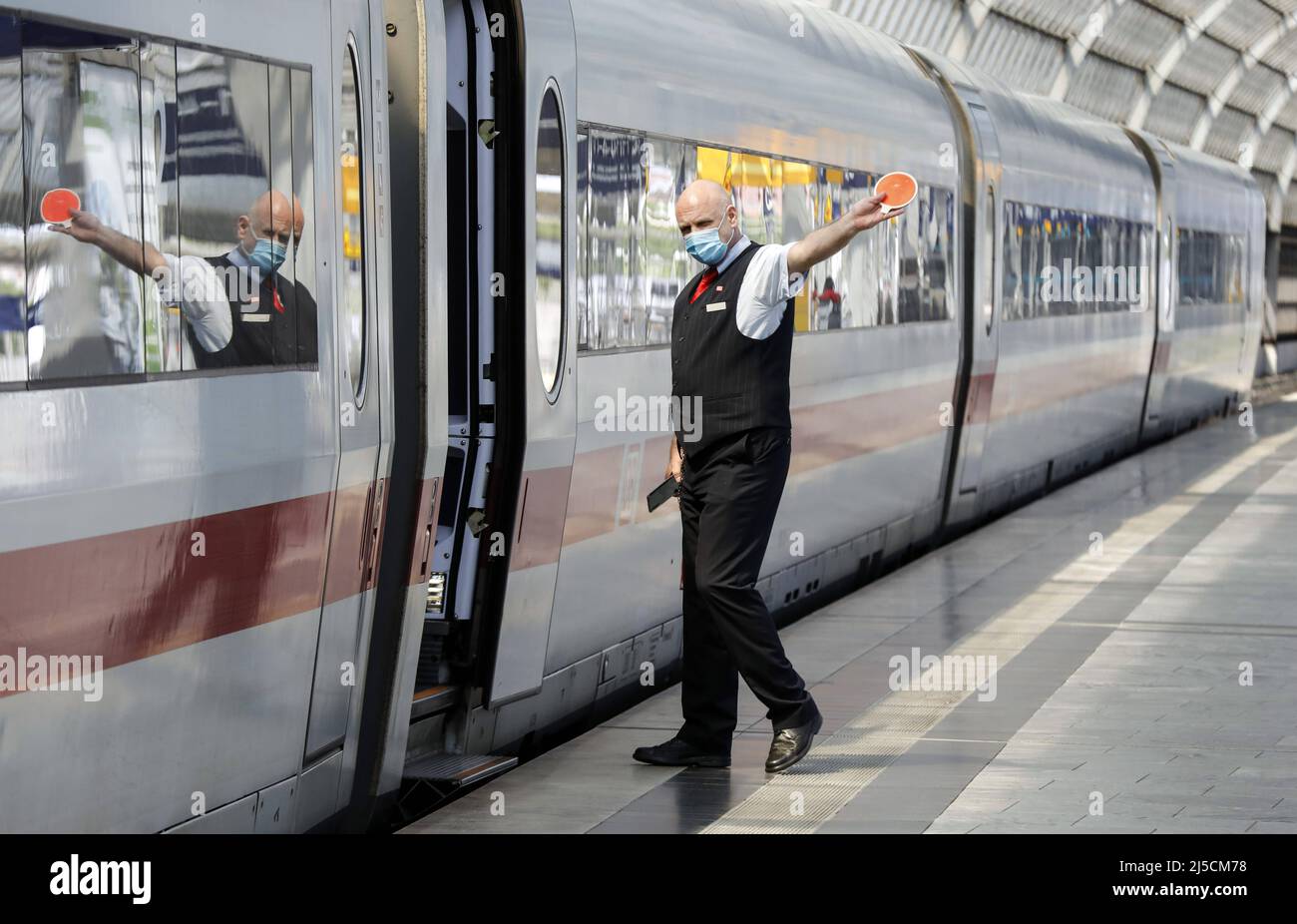 'Berlin, DEU, 27.05.2020 - Ein Zugbegleiter mit Gesichtsmaske gibt dem Triebwerksfahrer das Abfahrtssignal am Berliner Bahnhof Spandau. Bundesverkehrsminister, Deutsche Bahn und Betriebsrat schließen ein "Bündnis für unsere Bahnen". Die Allianz will die finanziellen Folgen der Corona-Pandemie für die Eisenbahnen regulieren die geplanten Milliardenhilfen für die Deutsche Bahn in der Corona-Krise treffen auf Bedenken der GDL-Gewerkschaft. [Automatisierte Übersetzung]' Stockfoto