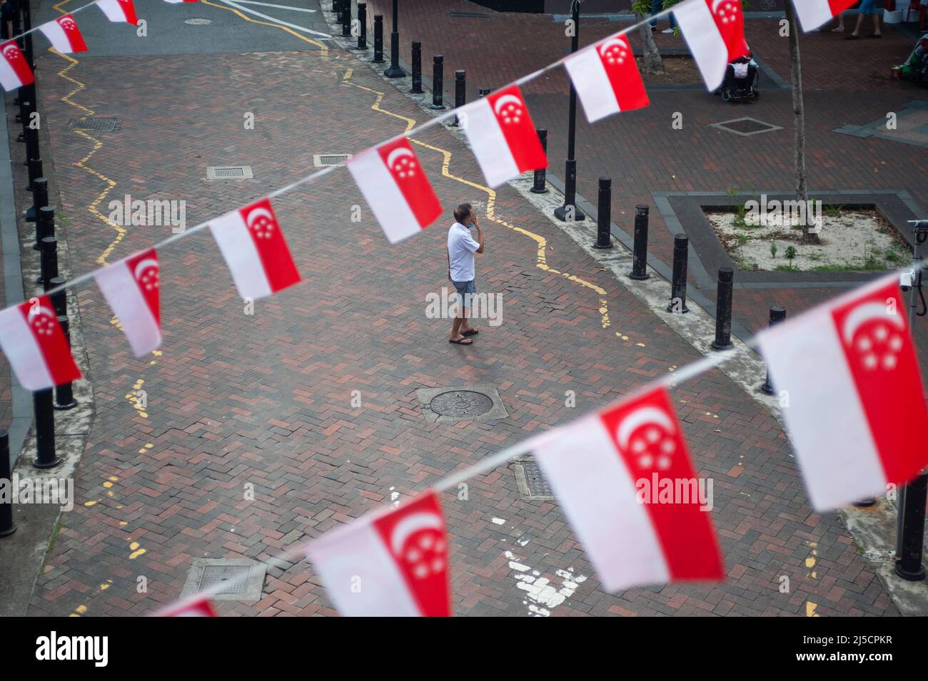 16.07.2020, Singapur, Republik Singapur, Asien - erhöhte Ansicht von kleinen Flaggen in den Nationalfarben des Stadtstaates, die als Wimpelfäden über eine Straße flattern, aufgehängt, um den bevorstehenden Nationalfeiertag am 9. August zu markieren. Aufgrund der anhaltenden Corona-Krise findet die diesjährige nationale Parade in einem viel kleineren Rahmen statt. [Automatisierte Übersetzung] Stockfoto