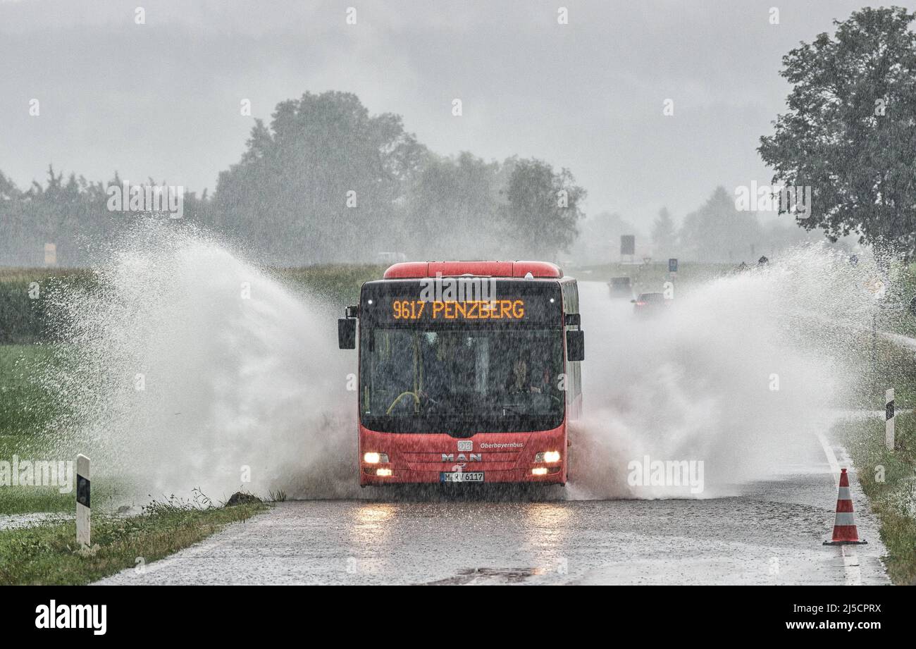 Nach anhaltenden Starkregen fährt ein Bus über die überflutete Straße zwischen Penzberg und Sindelsdorf. [Automatisierte Übersetzung] Stockfoto