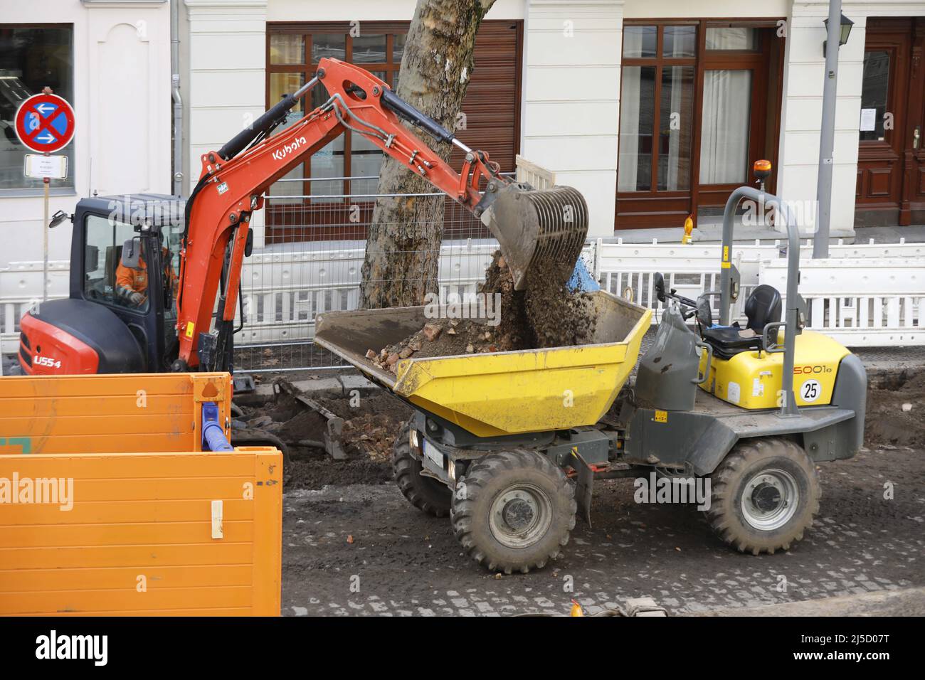 Berlin, DEU, 23.02.2021 - Bagger befüllen einen Baustellentaucher auf einer Straßenbaustelle. [Automatisierte Übersetzung] Stockfoto