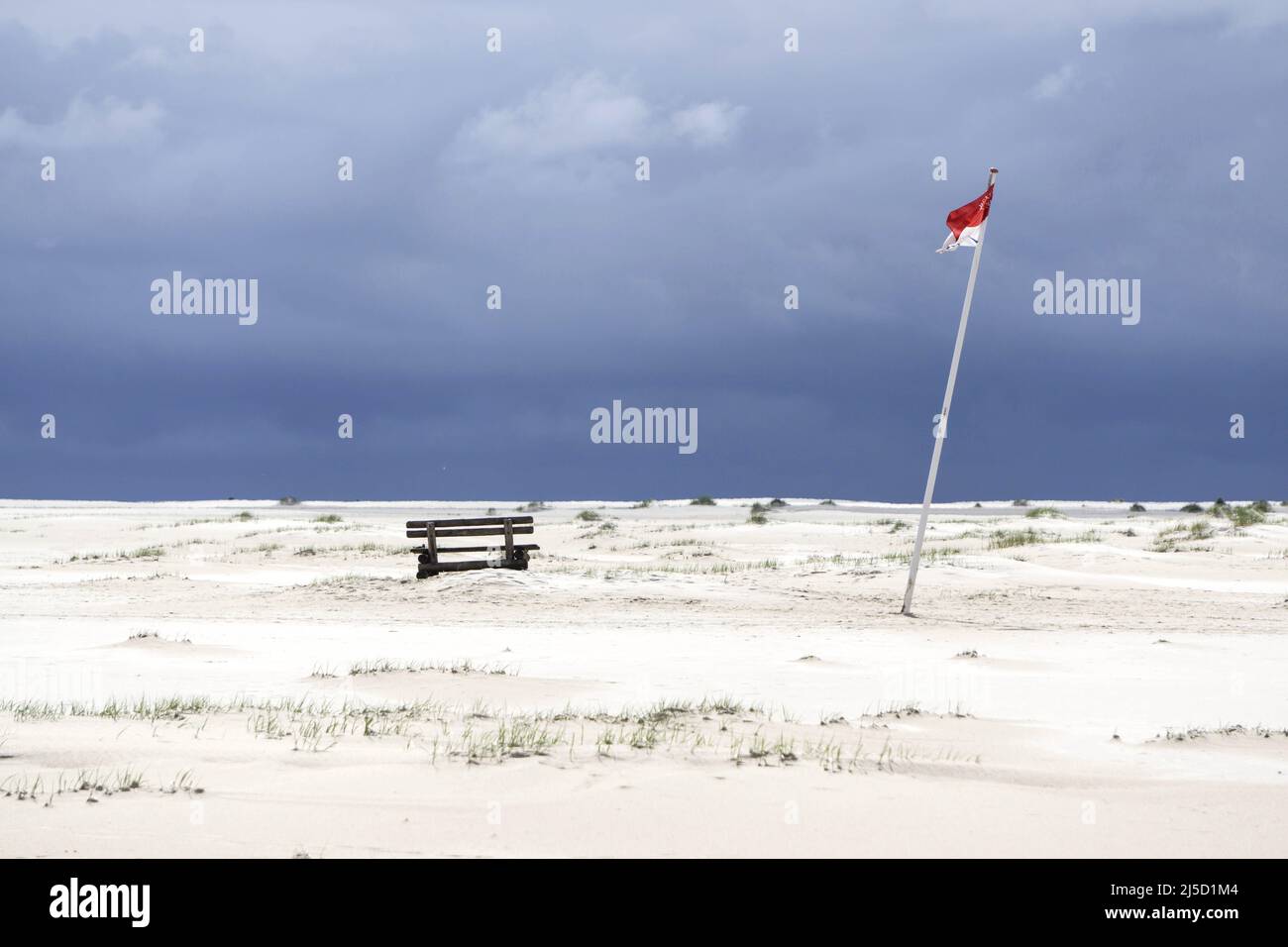 Amrum Island, Wittduen, 25.05.2021 - Bank und die Flagge von Wittduen im Kniepsand auf der Insel Amrum. Aufgrund abnehmender Inzidenzwerte ist eine Reise wieder möglich. Reise nach Schleswig Holstein nur mit negativem Testergebnis. Vor Ort muss alle 72 Stunden erneut ein Corona-Schnelltest durchgeführt werden. [Automatisierte Übersetzung] Stockfoto