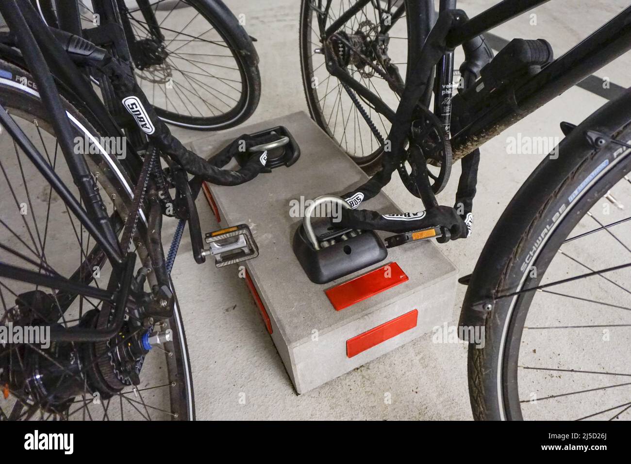 Berlin, 12.07.2021 - zwei Fahrräder werden mit Kettenschlössern an einer massiven Betonplatte gegen Diebstahl gesichert. [Automatisierte Übersetzung] Stockfoto