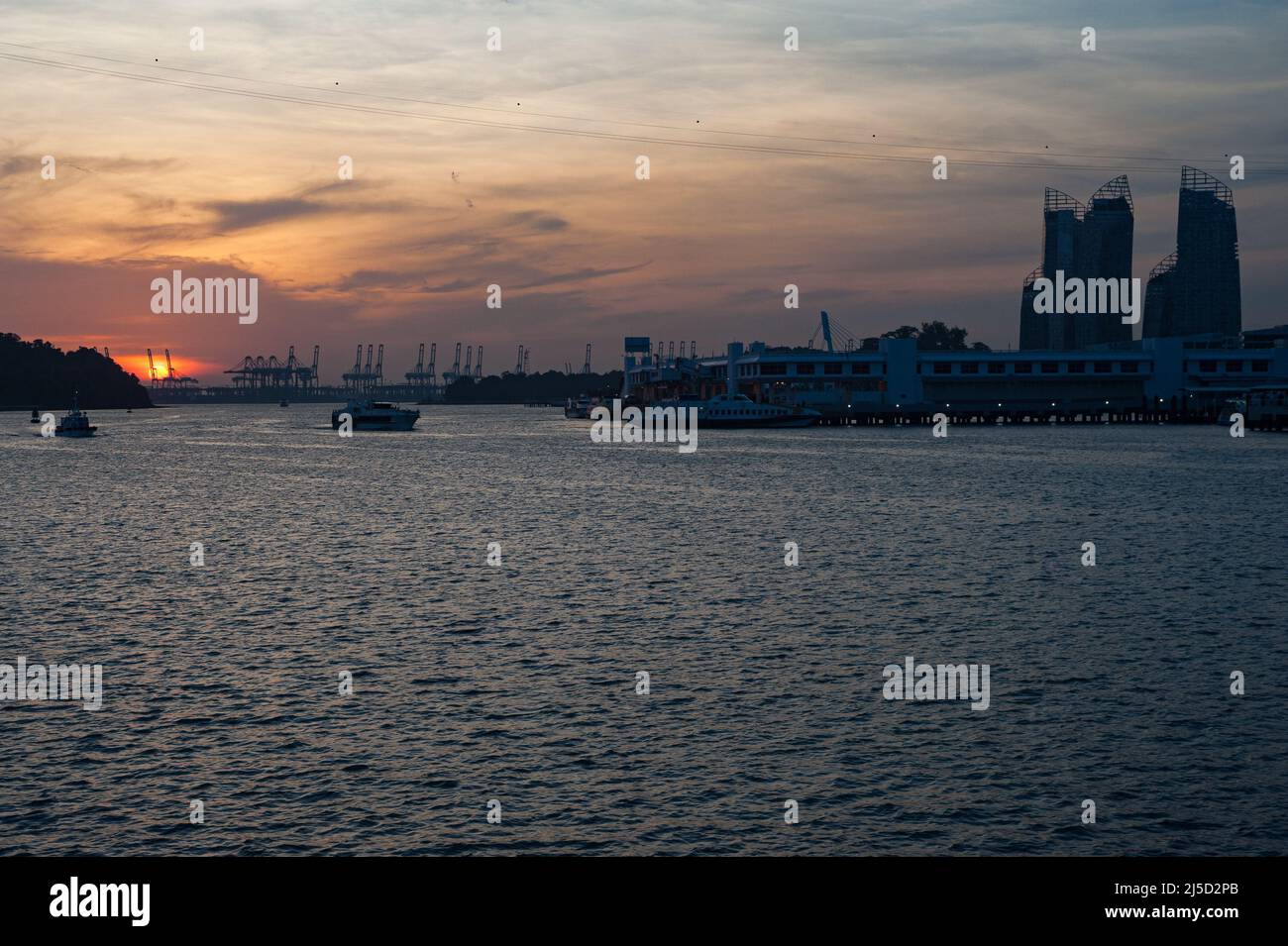 02.10.2016, Singapur, Republik Singapur, Asien - Blick vom Sentosa Boardwalk auf die untergehende Sonne über Harbourfront und Keppel Bay mit dem Containerhafen Pasir Panjang Terminal in der Ferne. [Automatisierte Übersetzung] Stockfoto