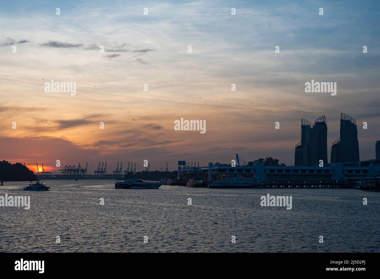 02.10.2016, Singapur, Republik Singapur, Asien - Blick vom Sentosa Boardwalk auf die untergehende Sonne über Harbourfront und Keppel Bay mit dem Containerhafen Pasir Panjang Terminal in der Ferne. [Automatisierte Übersetzung] Stockfoto