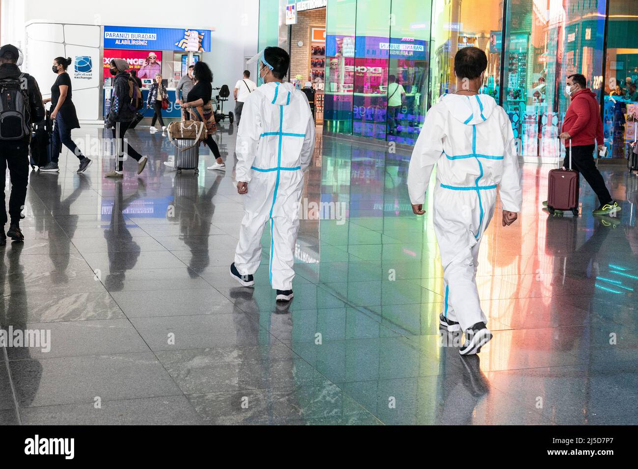 Istanbul, Türkei. 21. April 2022. Chinesen, die in Schutzsuiten, Masken und Gesichtsschilden ihrer Firma nach Afrika reisen, gehen während des Heiligen Monats Ramadan am Internationalen Flughafen Istanbul spazieren. Der Flughafen ist anlässlich des Ramadan schön dekoriert. Duty Free Geschäfte sind voll mit traditonellen türkischen Süßigkeiten wie Rahat Lokum bekannt als Turkish Delight, Halva, Souvenirs einschließlich Teppiche für Gebete und Shishas (Foto von Lev Radin/Pacific Press) Quelle: Pacific Press Media Production Corp./Alamy Live News Stockfoto