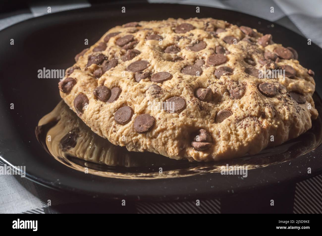 Großer Plätzchen mit Schokoladentropfen mit natürlichem Licht, hausgemachtes Rezeptkonzept. Stockfoto