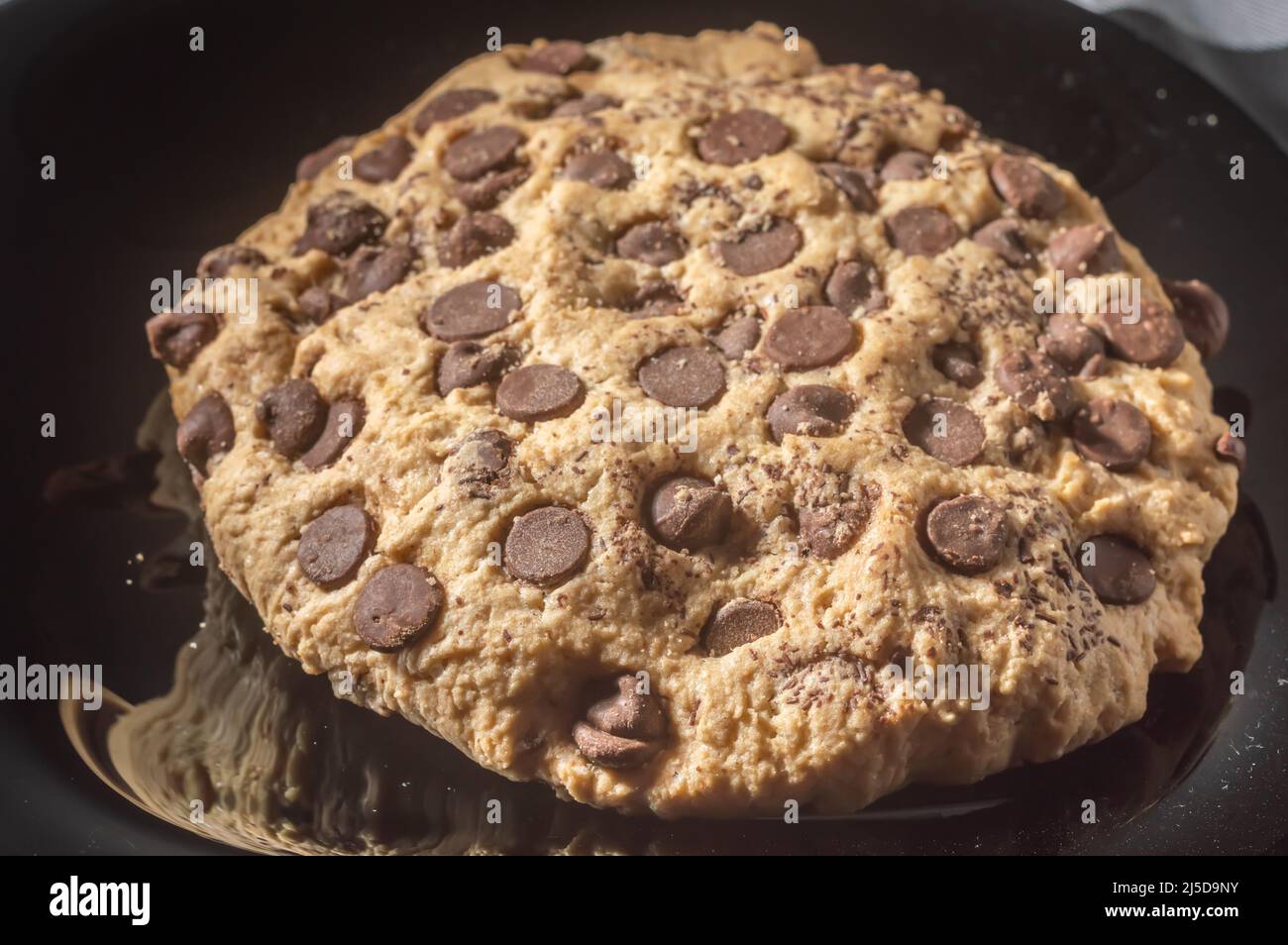 Großer Plätzchen mit Schokoladentropfen mit natürlichem Licht, hausgemachtes Rezeptkonzept. Stockfoto