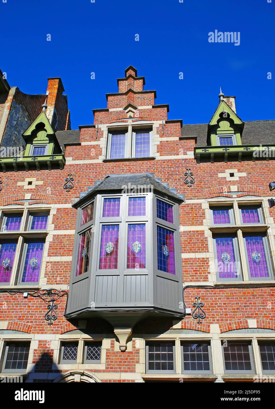 Lier, Belgien - April 9. 2022: Blick auf isolierte rote Ziegelfassade des mittelalterlichen belgischen Hauses, Giebeldach, Erker, klarer blauer Himmel Stockfoto