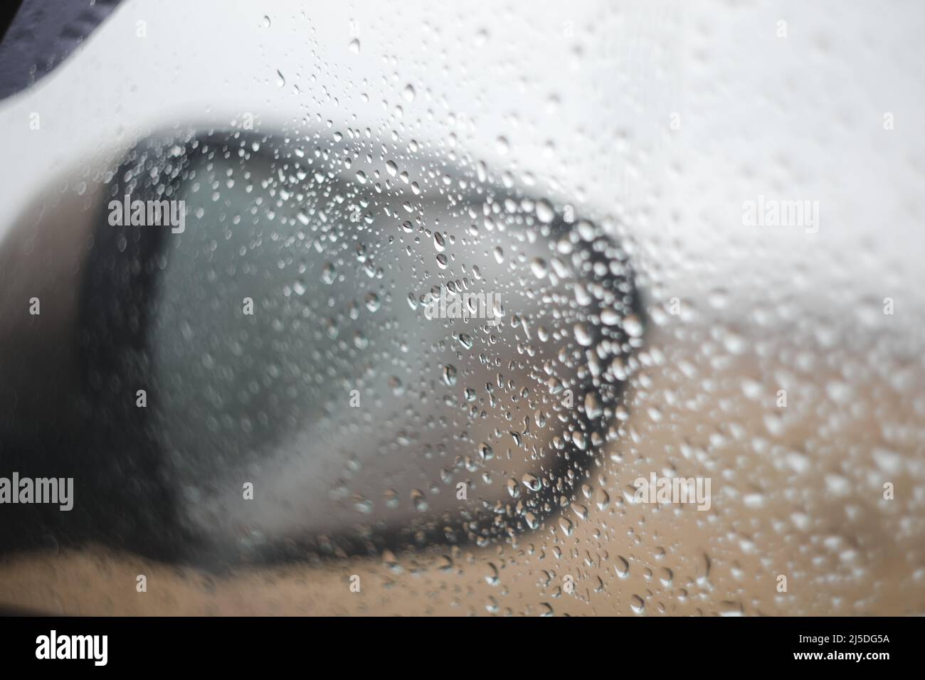 An regnerischen Tagen fällt Regen auf den Autospiegel und das Fenster Stockfoto