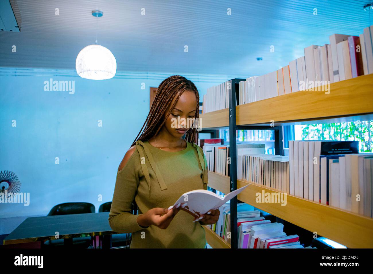 Kigali, Ruanda. 22. April 2022. (220423) -- KIGALI, 23. April 2022 (Xinhua) -- Ein Mädchen liest ein Buch in einer Bibliothek im A-Link Chinese Restaurant in Kigali, Ruanda, 22. April 2022. Die chinesische Gemeinschaft in Ruanda hat am Freitag eine Bibliothek im A-Link Chinese Restaurant in Kimihurura in Kigali, der Hauptstadt Ruandas, ins Leben gerufen. Die Bibliothek, die bisher unter anderem mit mehr als 5.000 Büchern in chinesischer, koreanischer und englischer Sprache ausgestattet wurde, zielt darauf ab, die Lesekultur der ruandischen Bevölkerung zu fördern. Die Themen der Bücher reichen von Literatur, Wissenschaft, Kultur, Technologie, Politik und Geschichte. Stockfoto