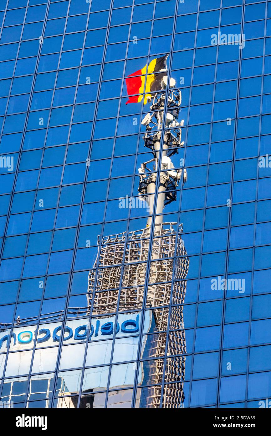 Spiegelbild des Turms Belgacom (heute Proximus) auf einer Glasfassade. Belgische Flagge. Brüssel Stockfoto