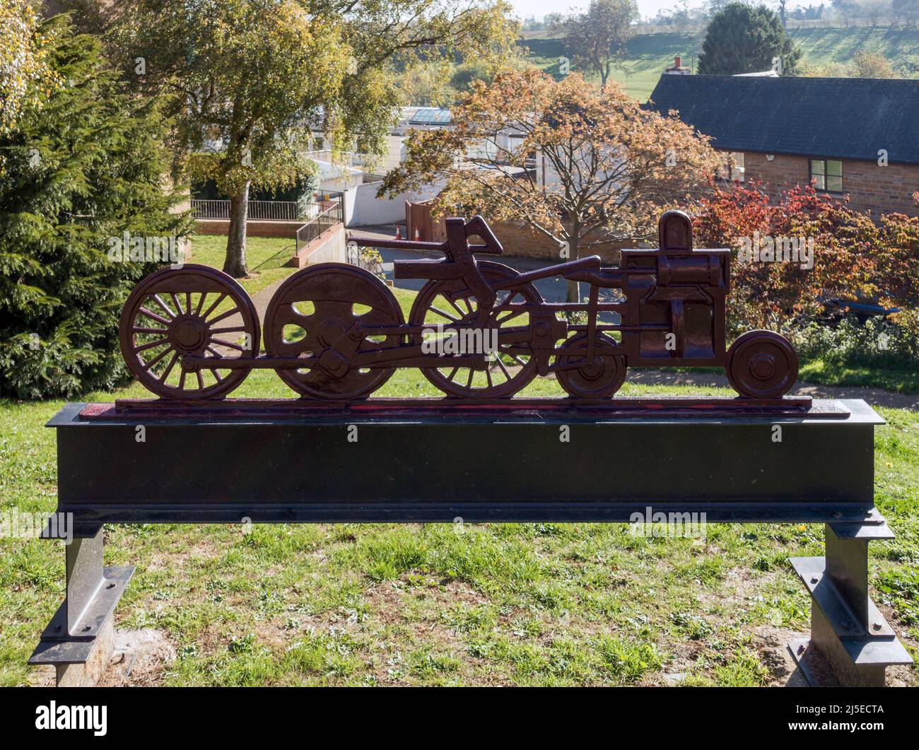 Denkmal am Bahnhof von Uppingham mit einem Metallmodell/einer Skulptur, die Dampfzug-Lokomotiven-Räder zeigt, South View, Uppingham, Rutland. Stockfoto