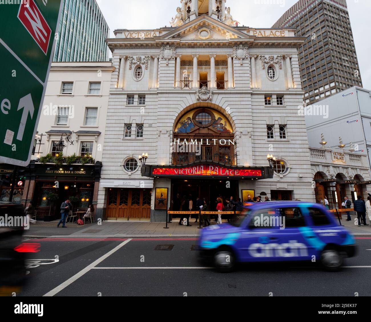 London, Greater London, England, 13 2022. April: Victoria Palace Theatre, Außenansicht Abendzeit, wenn ein Taxi mit Bewegungsunschärfen vorbei fährt. Victoria Street. Stockfoto