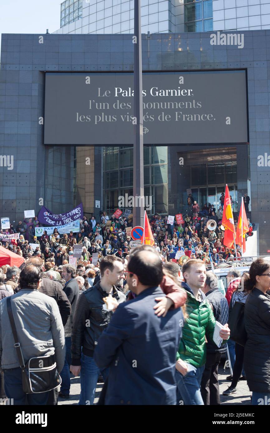 Jährliche Demonstration für Arbeitnehmerrechte im sonnigen Paris am 1rst. Mai mit dem digitalen Plakat: „Le Palais Garnier, l'un des Monuments les plus visités“ Stockfoto