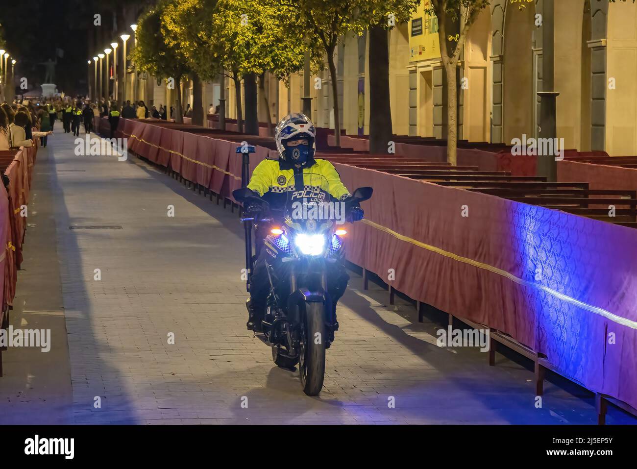 Huelva, Spanien - 15. April 2022: Spanische Polizei in Motorrad mit dem Logo der lokalen Polizei auf Uniform hält die öffentliche Ordnung in den Straßen von Huelva aufrecht Stockfoto