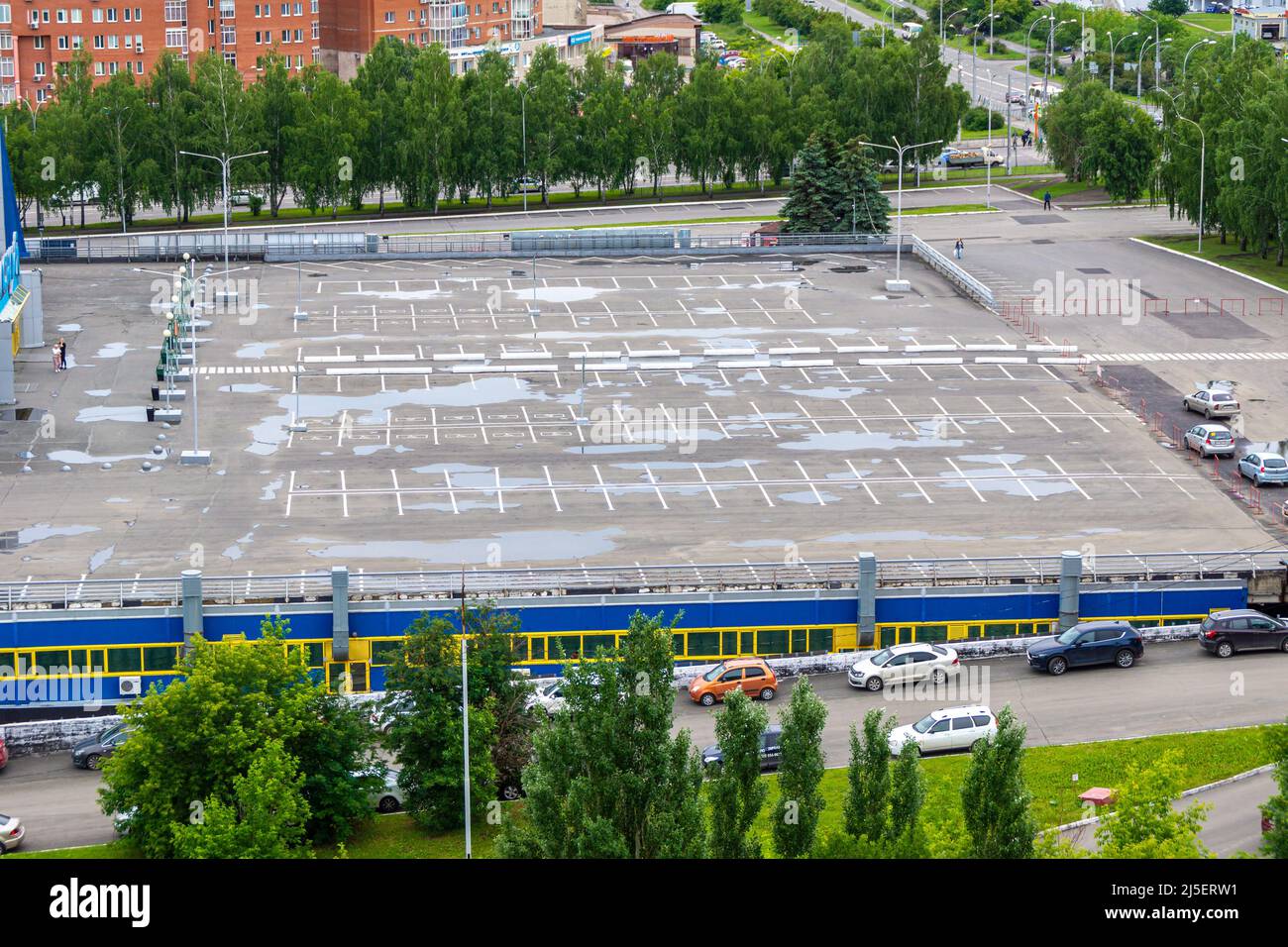 Kemerowo, Russland - 24. juni 2021. Großer leerer Parkplatz vor dem Einkaufszentrum, mit Lagerbereichen unter dem Parkplatz, selektiver Fokus Stockfoto