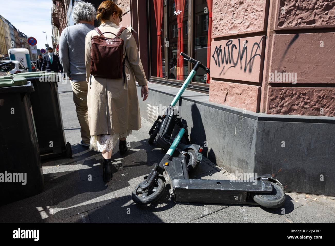 Frankfurt, Deutschland. 22. April 2022. 21. April 2022, Hessen, Frankfurt/Main: Passanten meiden geparkte E-Scooter in Frankfurt am Main. Frankfurt ergreift härtere Maßnahmen gegen das E-Scooter-Chaos. Bereits im vergangenen Sommer kündigte das Frankfurter Verkehrsministerium Maßnahmen an, um unter anderem das Parkchaos auf den Straßen deutlich zu reduzieren. Foto: Hannes P. Albert/dpa Quelle: dpa picture Alliance/Alamy Live News Stockfoto