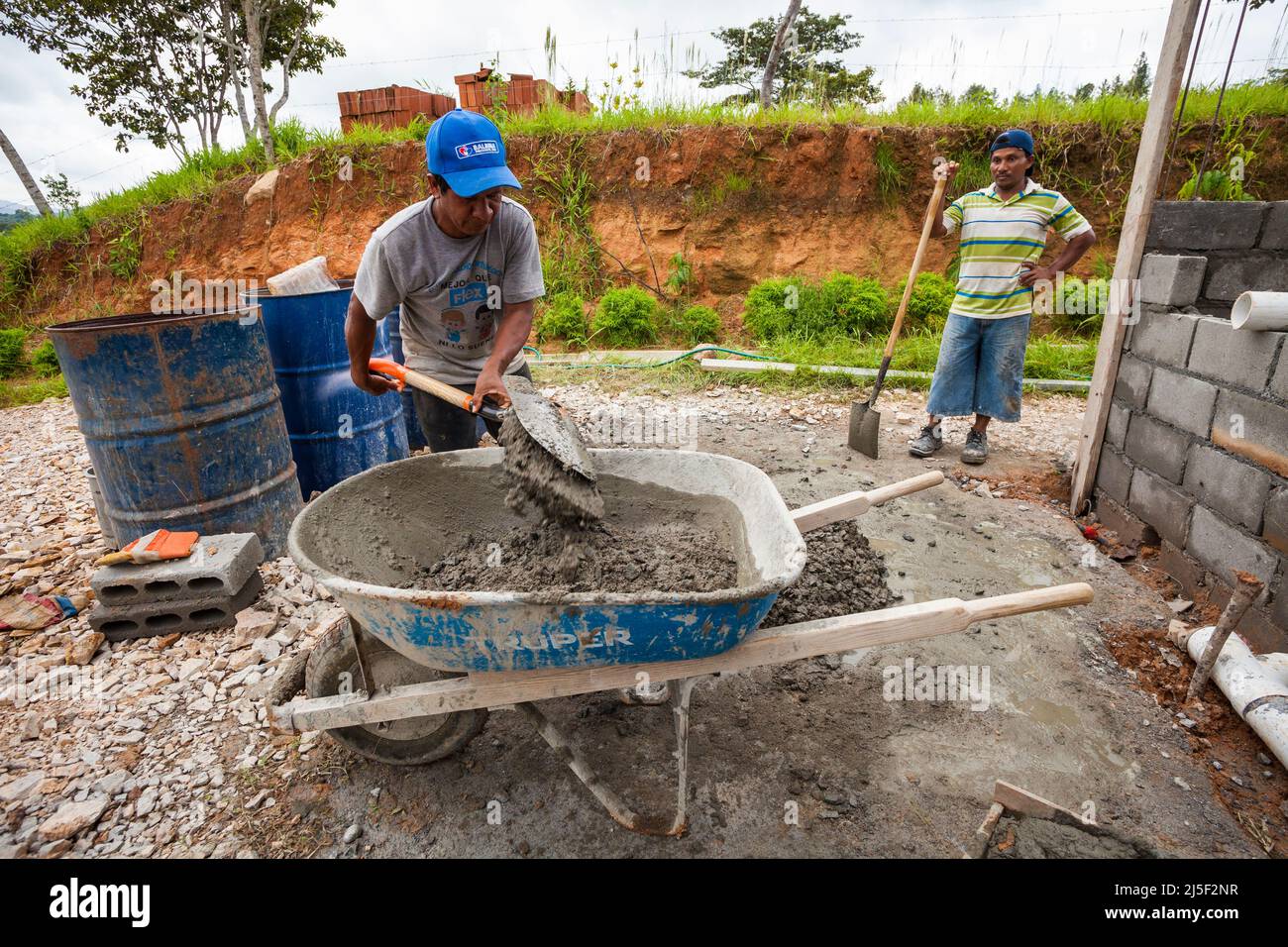 Zwei Männer mischen Zement, Sand und Wasser zu einer guten Betonmischung, um ein Haus in der Provinz Cocle, Republik Panama, zu bauen. Stockfoto