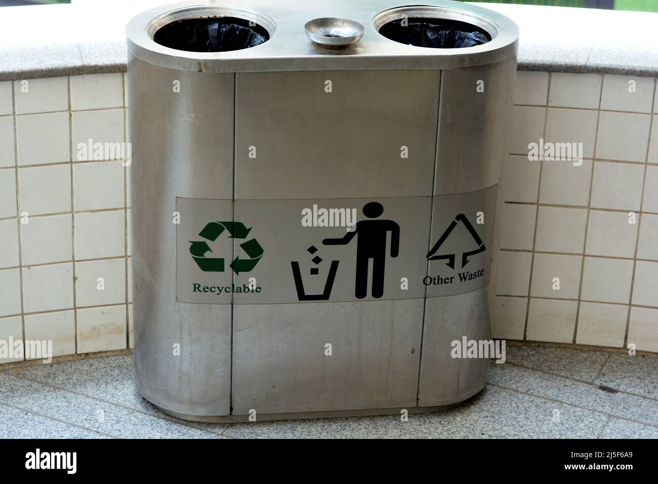 Recyclingfähige und andere Abfälle in einem Metallabfallbehälter aus Edelstahl für verschiedene Abfälle, Trennung und Sortierung von Abfällen, Behälter zum Sortieren von diffe Stockfoto
