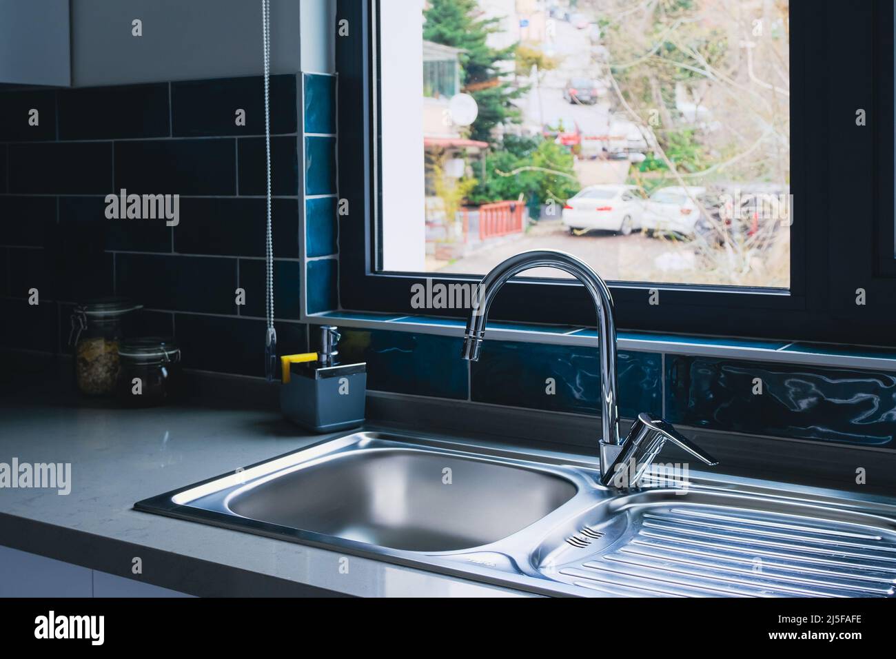 Saubere Spüle in der modernen Küche mit Blick auf das Fenster. Reinigungsservice und Immobilien Stockfoto